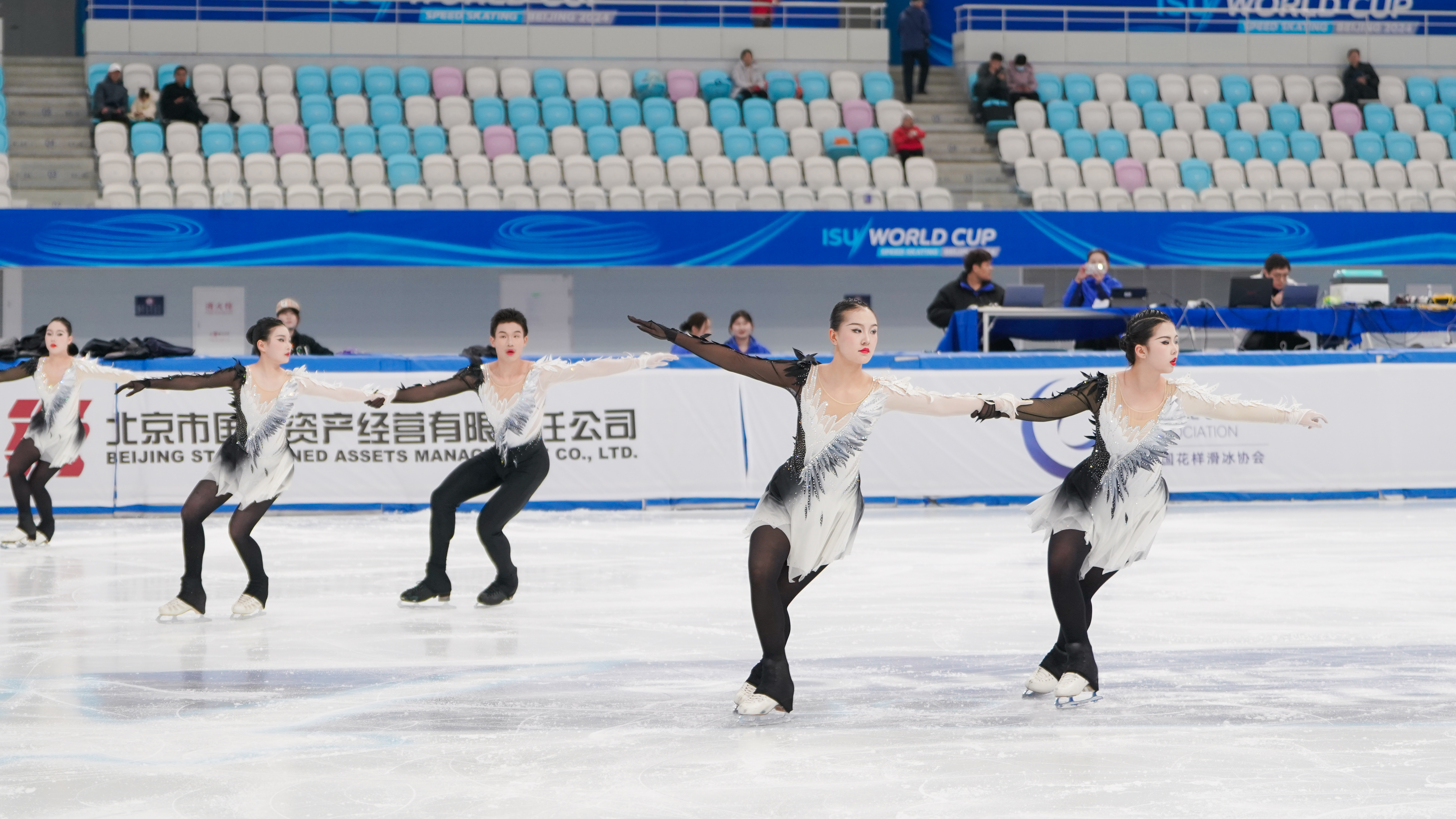 Figure skating team performing together on the ice